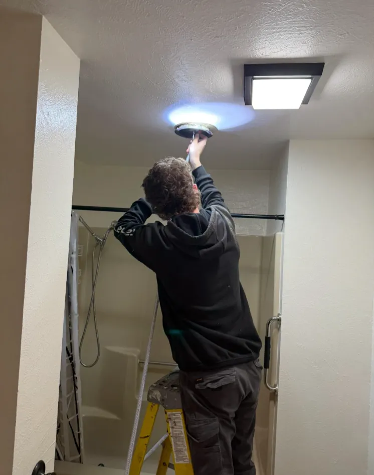Technician cleaning bathroom fan